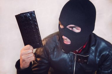 Hasta-amaçlanan delikanlı siyah maske takarak siyah deri kadın çanta tutar ve onun yağma için görünüyor. Hırsız cüzdanını çaldı. Yün bir çanta ile bir hırsız yarım kadeh. Yankesici ilişkisi.