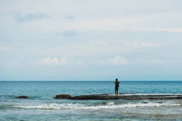 Giovane uomo scattare foto del mare in piedi sulla riva — Foto Stock