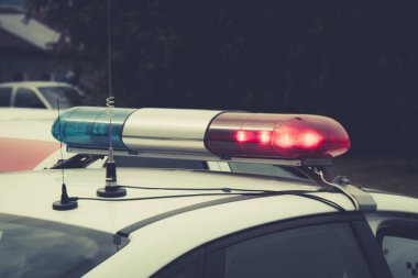 Bir polis arabasının döner sinyaline yakın. Flaşör ve anten ile polis devriye arabanın üst. Yanıp sönen ışıklar olan bir devriye arabası çatısı. Devriye arabası ışıkları. Trafik kazası
