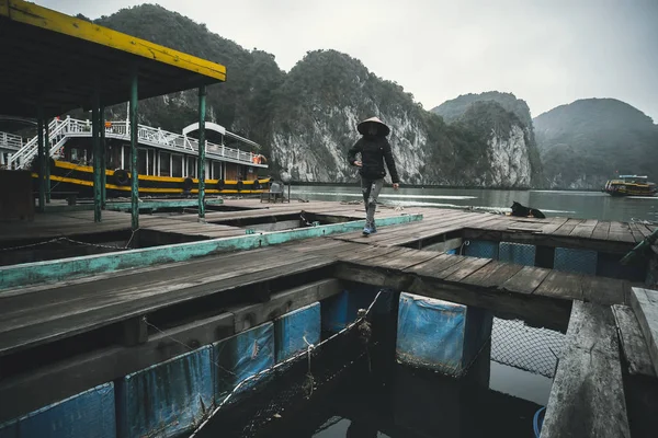 Allevamento ittico galleggiante in ha lungo golfo di Vietnam. Donna vietnamita che cammina in un allevamento ittico. produzione di pesce e molluschi in mare — Foto Stock