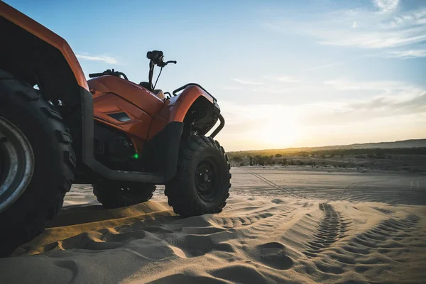 ATV Quad Bike en frente del amanecer en el desierto. ATV se encuentra en la arena en una duna de arena en el desierto de Vietnam. MUI ne — Foto de Stock