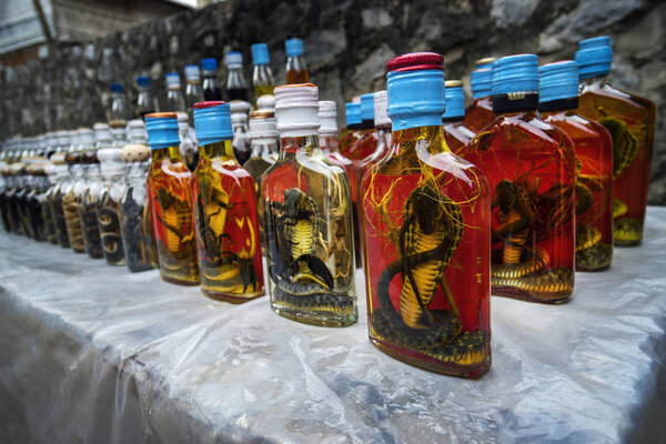 Bottle of Alcohol containing liquor with cobra snake and scorpion inside on a market