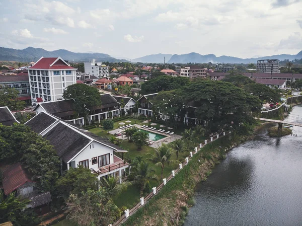 Stranden av Nam Song River med höga moderna byggnader i staden Vang Vieng. — Stockfoto