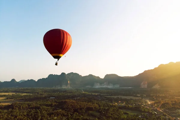 Colorful hot-air balloon raising just in time to explore beautiful sunset over Vang Vieng in Laos, Southeast Asia.