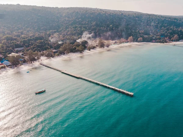 Birds eye drone aerial view of single pier in crystal clear blue sea on secluded beach on Cambodian island Koh Rong on sunny summer — Stock Photo, Image