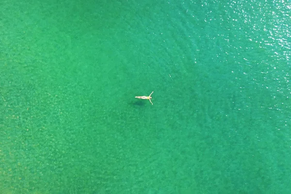 Vista superior de la mujer joven en bikini brillante está nadando en el mar transparente y azul. Vista aérea de mujer delgada flotando en el agua del mar de Andamán . — Foto de Stock