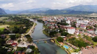 Vang Vieng köyünde Nam Song Nehri üzerinde Bambu köprü, Laos. Şehrin en iyi görünümü. Kentsel peyzaj. Asya'nın güzel doğası.