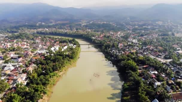 鸟瞰老挝的勃拉邦和周围郁郁葱葱的山脉。湄公河的支流南卡恩河在右侧和平流动. — 图库视频影像