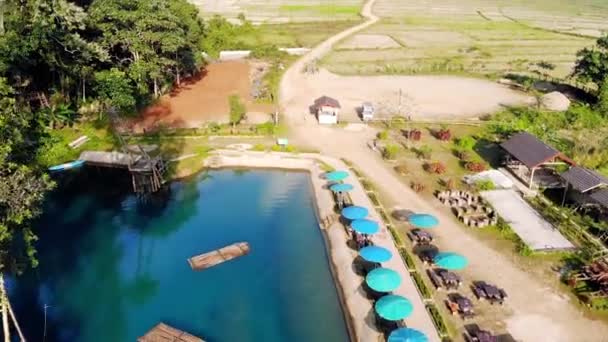 Blue Lagoon, Vang Vieng, Laos. vliegen over rijstvelden op de achtergrond van hoge bergen en heuvels — Stockvideo