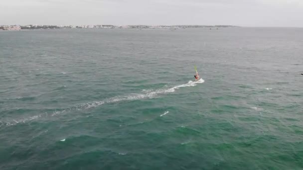 Extreme man atleet zwemt op de wind surfen op de zee Golf tegen de blauwe zee en de horizon. Extreme watersporten. beweging van het rode zeil op het water. zomer pret op zee. — Stockvideo