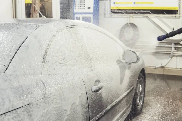 Coche está cubierto de espuma para lavar el coche. Lavado automático de autos. Champú para autos. Proceso de limpieza — Foto de Stock