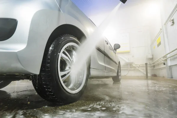 Vehículo de limpieza de hombre con pulverización de agua a alta presión o chorro. Detalles de lavado de autos. lavar la rueda trasera de un coche —  Fotos de Stock