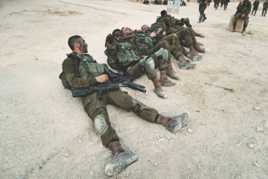 Masada, İsrail. 23 Ekim 2018: İsrail Ordusu askerleri yerde yatarak manevralar ve masada kalesine yürüyüş-atma sonrasında dinleniyor.