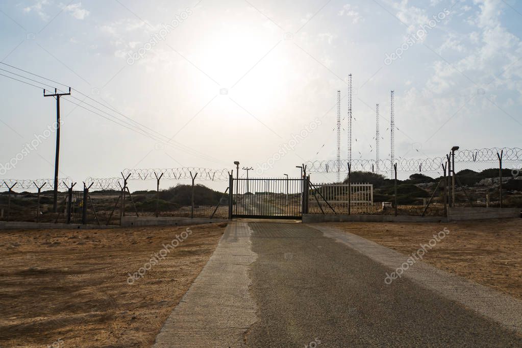 Automatic metal gate. Barbed wire fence block the way. gate to a closed area.