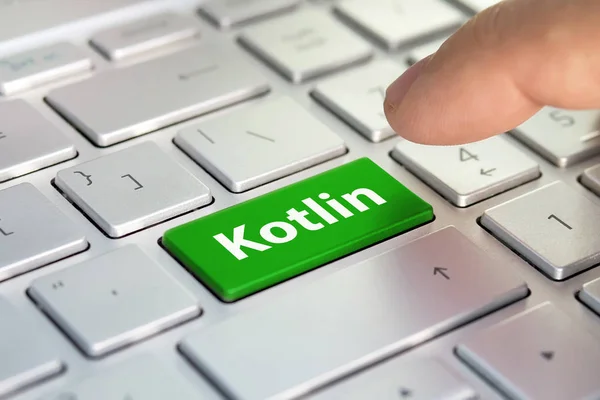 Kotlin computer language. writing on button modern of gray laptop. Finger presses the button. Programmer for work.