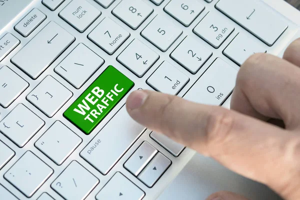 Keyboard with web traffic button. Computer white keyboard with web traffic button. male finger presses a color button on a gray silver keyboard of a modern laptop. Button with inscription close up.