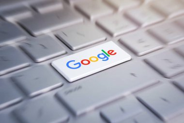 Modern bir dizüstü bilgisayarın gri klavyesindeki şirket logosunun yer alan beyaz düğmesi.