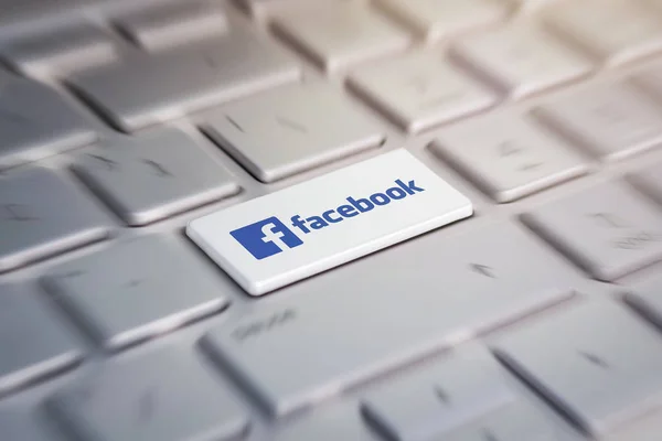 Bottone con il logo aziendale facebook sulla tastiera grigia di un moderno laptop . — Foto Stock