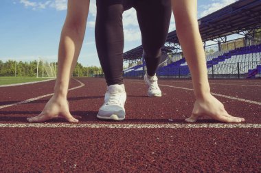 Başlangıç konumu yolda atletik genç kız. İleri hareket kavramı.