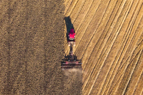 Niska wysokość anteny góra dół zdjęcie łąki i rolnik w ciągniku cięcie pola trawy po tym cięte trawy może wyschnąć i być zabierani, więc może być stosowany jako karma dla zwierząt dla krów. — Zdjęcie stockowe