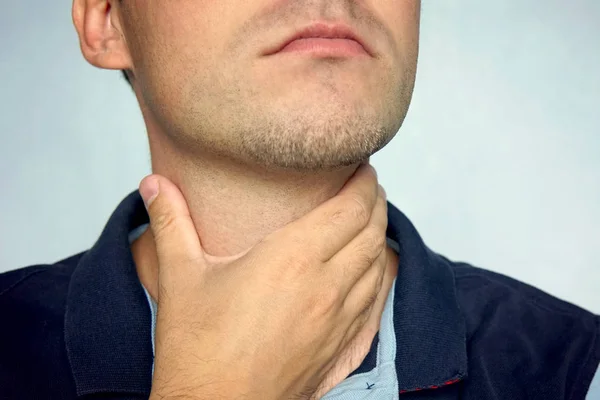 Personas, cuidado de la salud y el concepto de problema - hombre infeliz tocándose el cuello y sufriendo de dolor de garganta sobre fondo azul . — Foto de Stock