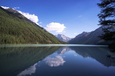 Bright evening. Lake kucherlinskoe. Calmness, serenity. Altai Mountains, Siberia. Russia. blue clear water in the mountain lake. Wildlife of the taiga clipart