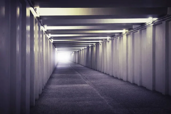 Изображение света в конце подземного бетонного тоннеля. Длинный бетонный тоннель с фонарями в подземелье города. Подземный переход — стоковое фото