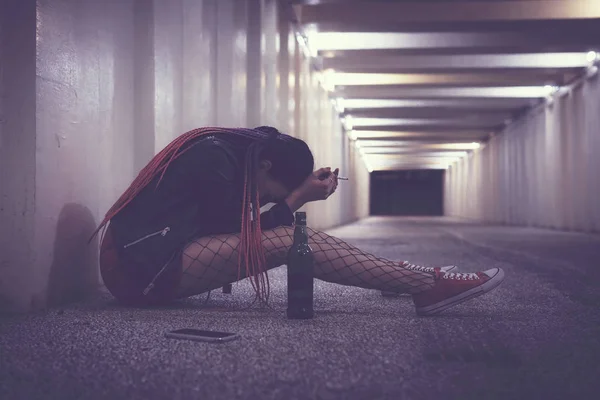 La chica triste, la chica anhela. Una borracha deprimida sin hogar llorando en el paso subterráneo. durante la noche . — Foto de Stock