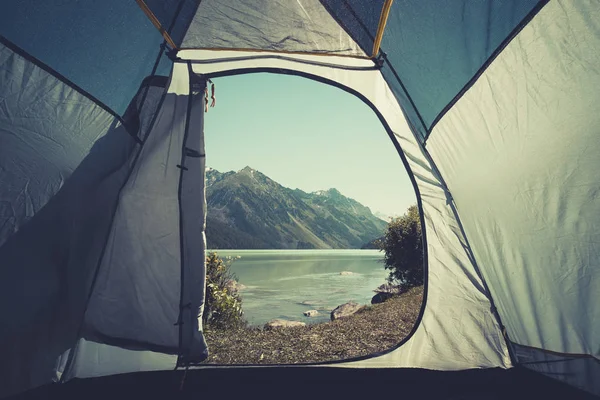 Blick vom offenen Zelt auf den wunderschönen Bergsee. das Konzept von Tourismus und Reisen. Zelten im Wald. Bergsee kucherlinskoe von oben, altay, russland — Stockfoto