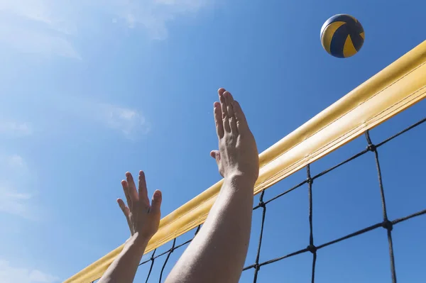 Beachvolleyballerin in Aktion bei sonnigem Tag unter blauem Himmel. Hände aus nächster Nähe greifen nach Ball — Stockfoto