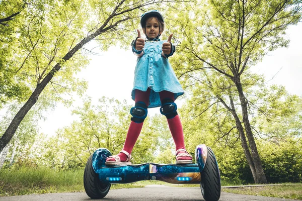 Mädchen reitet auf einem modernen Board des Selbstbalancierens mit einer Katze im Wald in einem Sommerpark. Aktiver Lebensstil. Elektroroller. Schwebebrett. neues Selbstausgleichsgremium. Kreiselroller — Stockfoto