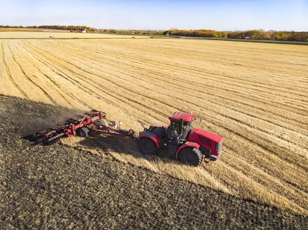 Oogsten van tarwe in de zomer. Een rode rooier die in het veld werkt. Uitzicht van bovenaf. haying, hooioogst. — Stockfoto