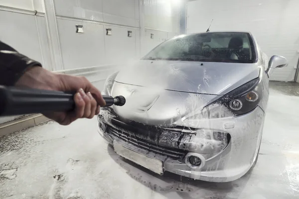 Limpieza de coches deportivos usando agua de alta presión. Hombre lavando su coche bajo agua de alta presión en servicio. El trabajador del hombre lava el coche. autoservicio — Foto de Stock