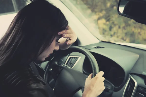 Conductora sintiendo ansiedad al volante. Primer plano de niña llorando sentada dentro del vehículo y llorando. La conductora sintió dolor de cabeza y enfermedad al conducir. Mujer cerró los ojos y toca su frente . — Foto de Stock