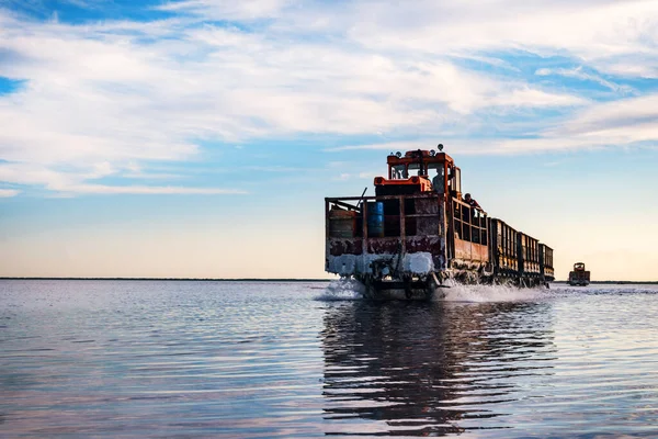 train travels from water. Mined salt in Lake Burlin. Altai. Russia. Bursolith. Old train rides on the railway laid in the water through the salt lake.