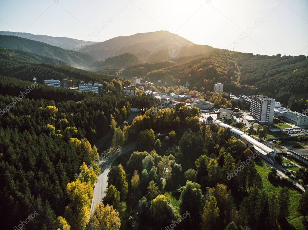 Aerial view of a small town in the Altai territory. Top view of the resort town Belokurikha. Bird's-eye view of the houses among the forests on the slopes of the mountains.