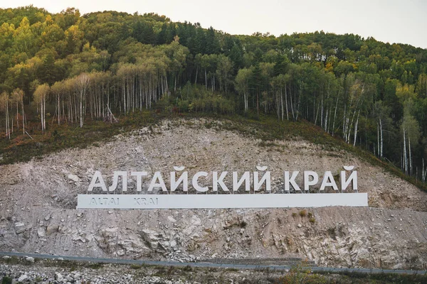 Inscrição em língua russa Altai Krai é o nome de uma região na Sibéria Ocidental, na Rússia. Cartas numa rocha perto da estrada serpentina. aglomerado turístico Belokurikha 2 — Fotografia de Stock
