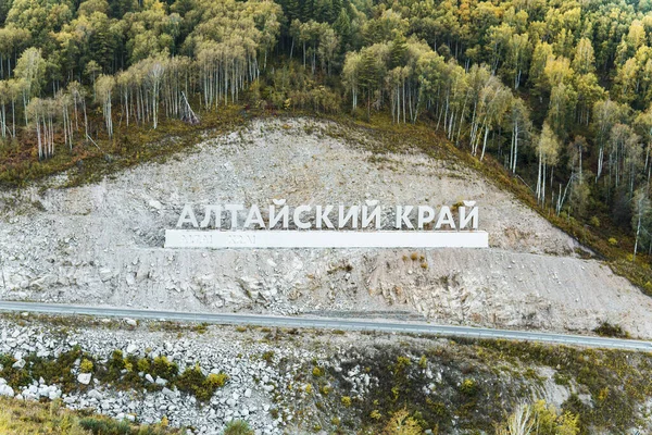 Inscrição em russo Altai Krai é o nome de uma região na Sibéria Ocidental, na Rússia. Cartas numa rocha perto da estrada serpentina. cidade Belokurikha 2 — Fotografia de Stock