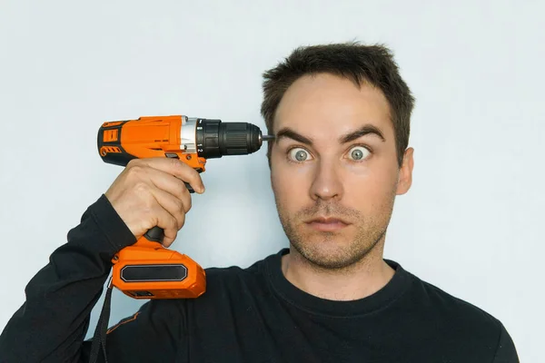 Out of my mind. male Builder drills his brains out. Crazy guy with a stupid face. Fatigue from hard work. Inadequate customer. portrait of a psychopath close up — Stock Photo, Image