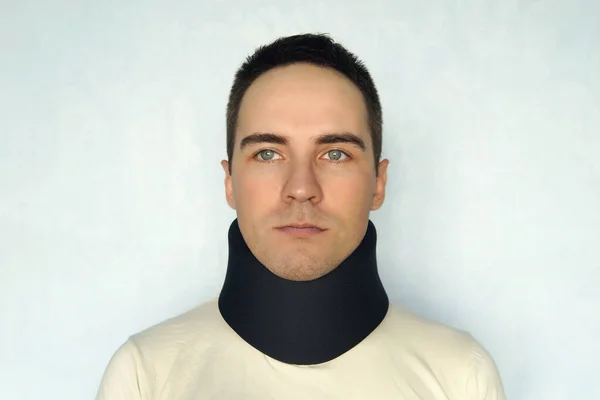 Boynundaki kırığı düzeltmek için siyah yakalı hasta bir adam. Tıbbi boyun tasması. — Stok fotoğraf
