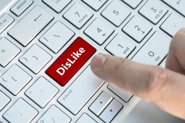 Klavye tuşundaki bir nefret. Bir erkek parmak modern bir dizüstü bilgisayarın gri gümüş klavyesinde bir renk düğmesine basar. Üzerinde yazı olan düğme. Kapatın..