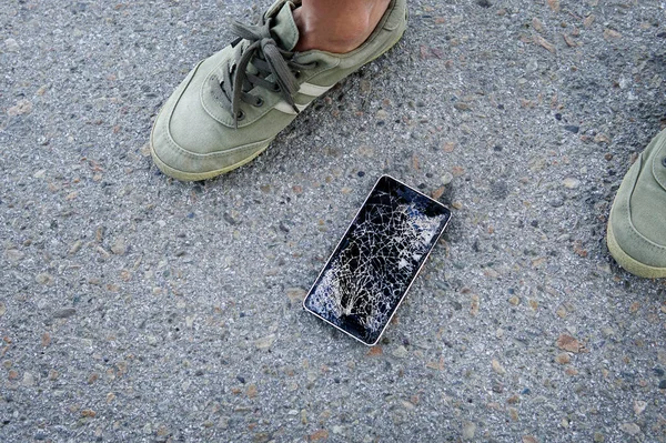 Kırılmış, parçalanmış, mahvolmuş modern cep telefonu, cep telefonu, cep telefonu, telefon. Kırık, çatlak ekran ve hasarlar. Asfaltta kırık ekranlı telefon. Birisi aygıtı düşürdü. — Stok fotoğraf