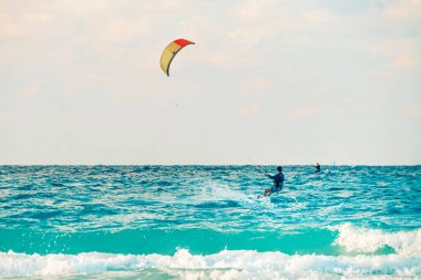 Kiteboardcu uçurtma atleti uçurtma sörfü numaraları yapıyor.