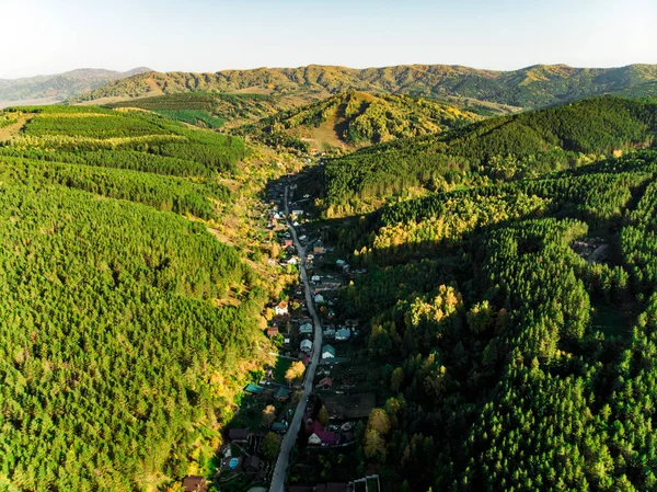 Top view of the resort town Belokurikha. Bird\'s-eye view of the houses among the forests on the slopes of the mountains. Aerial view of a small town in the Altai territory