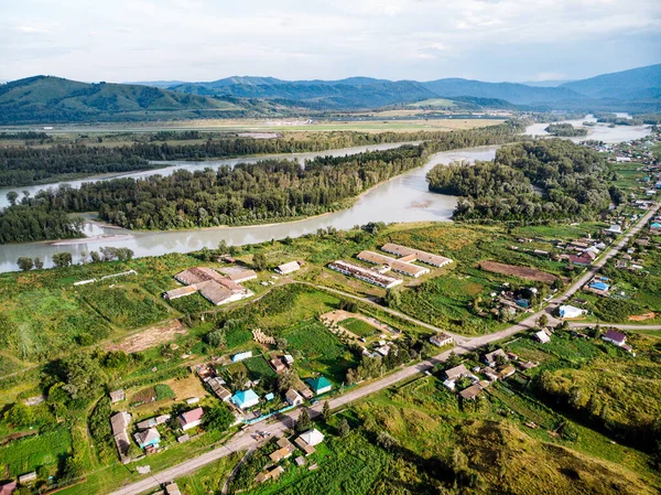 Village in Russia, Altai Mountains, houses and Katun River. Top view of the mountain river in the Altai mountains and the village of Aya. Altai territory.