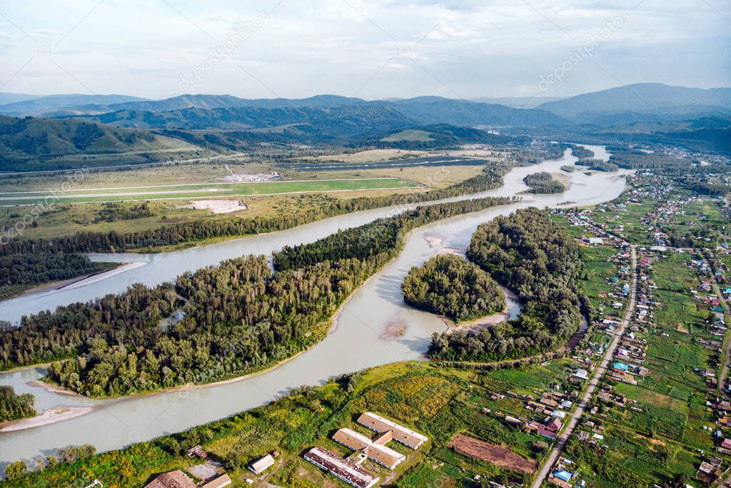 Aerial view of Katun river, in Altai mountains. Top view of the mountain river in the Altai mountains and the village of Aya. Altai territory.