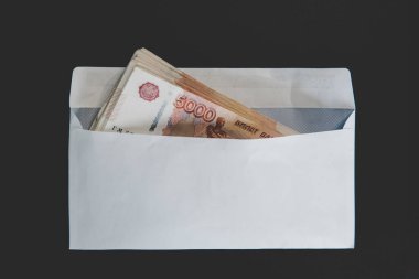 Large denominations of 5000 rubles in a white envelope. A man hand holds an envelope with money. the concept of bribery and corruption clipart