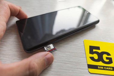 Bir 4G SIM kartı, mağazanın ahşap masasına yakın 5 gramlık yüksek hızlı SIM kartıyla değiştirmek
