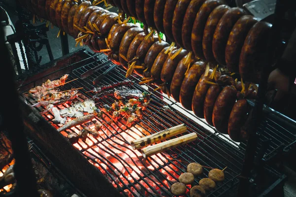 Smoked sausage hanging over the grill. The process of Smoking sausage. Cooking street food on the grill