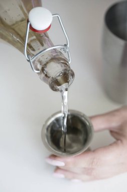 kız şişe içecek bir ölçüm cam içine dökün. kız bir şişeden ölçme bardak şeker şurubu dökülen.